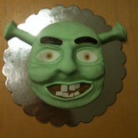 Shrek The nose, "ears", eye brows, etc are all sculpted from fondant. Entire cake covered in fondant.I carved out the shape of his face...