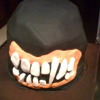 Masked Monster Cake Yellow cake with orange buttercream filling. The face mask, cake, and teeth were all made from fondant. The mask has laces up the back.