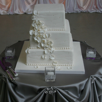 All White Elegance Three layered, fondant covered, square wedding cake inspired by the bride's dress and The Caketress. Flowers were handmade from...