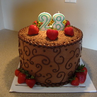 My Husbands Birthday Cake Three 10" staked devils food cakes with 2 layers choc. mousse filling. Iced with whipped milk choc. Scroll & border with dark choc...