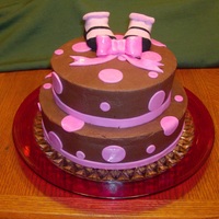 Baby Shower Chocolate cake, Chocolate butter cream with Raspberry filling. MMF dots and bow - booties are real baby booties supplied by the grandma to...