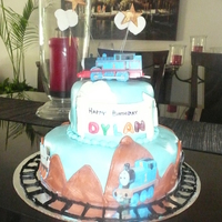 Thomas The Train Two Tier rainbow cake wrapped in MMF. All details are fondant and edible paper.