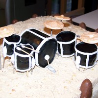 Drum Set Drums are out of cereal treats covered in fondant and air brushed. Cymbals are out of gumpaste dusted with luster dust. Frosting is peanut...