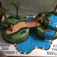 Dora Used deco pack from wal-mart. Buttercream icing, fondant flowers, pretzel trees, and oreo stick bridge. One of my fave cakes.