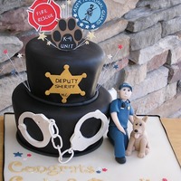 Pilice Officers Grooms Cake Two tier topsy turvy cake covered in Black fondant.Handmade groom to be and his K-9 officer; Morris.Handmade handcuffs from gumpaste and...