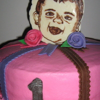 Tiffani's First Birthday Cake This cake was created back in December for my niece's first birthday. Her face is a chocolate portrait. Ribbon roses and ribbon are...