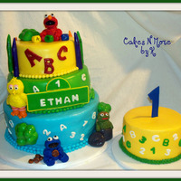 Sesame Street First Birthday Cake Red Velvet Cake filled with Strawberry N Cream filling with cream cheese icing covered in fondant. Smash cake is buttercream. Cute Cake! I...