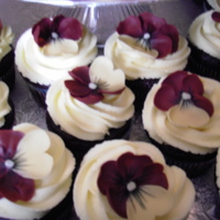 Burgundy Pansies Burgundy and yellow pansies on dark chocolate cupcakes with yellow vanilla buttercream icing. They went with a cake for a graduation party...