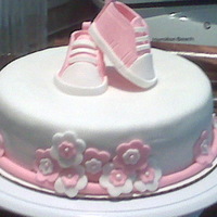 Converse Shoes Baby Shower Cake Gumpaste converse shoes, fondant covered cake with fondant flowers.