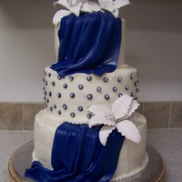 My First Drapes Vanilla cake filled with white chocolate butter cream and raspberry filling. Covered with vanilla butter cream, and marshmallow fondant....