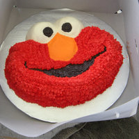 Elmo Cookie Cake This is a chocolate chip cookie cake. A cookie cake is a really really big cookie!! :D Yumm! Its decorated with buttercream icing.