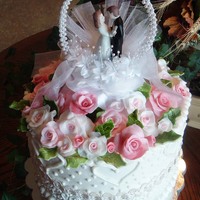 Small Wedding Cake French vanilla cake with French vanilla cream cheese buttercream frosting and fondant flowers and leaves. Everything is edible, except for...