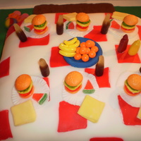 Picnic Table This is my 5th cake and I learn a little something from each one. This is all fondant, with candy burgers, soda, fruit, etc. The napkins...