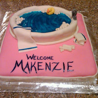 Baby Bath Bsic Butter Cake. Oval cake, cut shallow for the tub, and covered in white fondant. Water is blue glitter gel for a liquid look. Soap,...