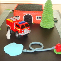 Fire Station Chocolate cake with vanilla cream filling. Buttercream icing with black sugar for the roof. the roads, fire hose and water puddle are...