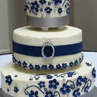 White, Navy, And Silver Wedding Cake This is my first wedding cake--three tiers with two different types of cake, white chocolate cream cheese buttercream. Flowers and the &...