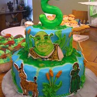 Shrek Cake butter cream yellow cake with chocolate filling. the "shrek" characters were hand painted on fondant. the swamp sludge is green...