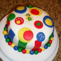 First Fondant Covered Cake White cake with layers colored yellow, red, blue & green to match fondant decor. Vanilla BC with fondant