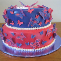 Butterflies I made over 100 gumpaste flowers for this baby shower cake. I covered it in purple and pink MMF, and painted it with pearl dust.