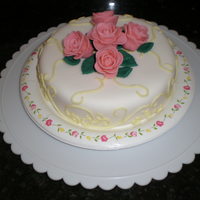 Two Layer Lemon Cake Two layer lemon cake with organic strawberry filling and lemon butter cream icing. Cake is covered in fondant with fontand roses and leaves...