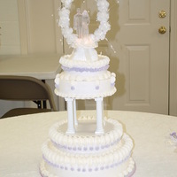 Round White Wedding Cake With Lavender Accents Wedding cake for a very young bride. I was really surprised when she picked this frou-frou cake from a Wilton year book. Not the easiest...
