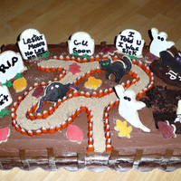 Halloween Graveyard Cake 12x18 cake with fondant fence. Decorations made with cookies, brownies and modeling chocolate.