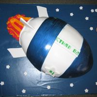 Rocketship Cake Child's birthday cake. Fondant with blue luster dust painted on two blue fondant sections. Fondant stars and planet on a board covered...
