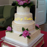 Ivory Buttercream Wedding Cake Fresh Peonies on an ivory buttercream cake with white buttercream ribbon and brush embroidery/scrolls.