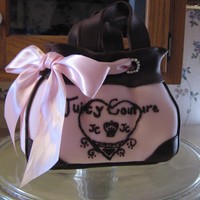 Pink Juicy Purse carved from three layer stacked cakes,covered with pink fondant. Top of purse is chocolate leather.