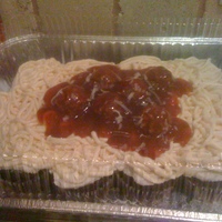 Spaghetti And Meatballs Buttercream icing piped from a plastic Zip Lock bag; hazelnut chocolates; strwberry jam, and shredded coconut.