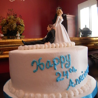 Still Holding On After 24 Years! 2 layer carrot cake with buttercream icing for a 24th anniversary. Iced in buttercream with a wedding topper on the top.
