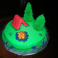 Campout Cake My first cake...all buttercream. Upside down waffle cones for trees. Graham crackers for tent shape. Pretzels for campfire. Rock with black...