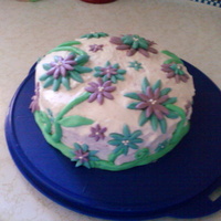 Gerbra Daisy Birthday Cake This cake is red velvet with white buttercream. The flowers, leaves, and stems are made with fondant.