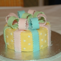 Yellow Bows 6" round Madeira cake with yellow fondant, white stars and pastel coloured bows & ribbons. Taken from the Wilton fondant book for...