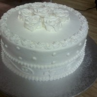 White On White Anniversary Cake White cake, strawberry filling, with almond buttercream and royal icing roses.