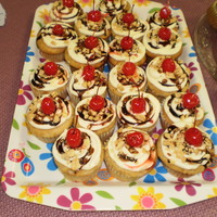 Banana Split Cupcakes banana bread cupcakes, with cream cheese frosting, sprinkled with nuts, drizzled in chocolate sauce & topped with a cherry!