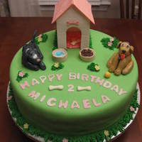Puppy Cake This is a two layer, 12 inch marble cake. The dogs and dog house were made with gumpaste. The other pieces were made using fondant.