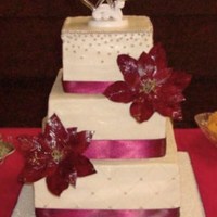 Christmas Wedding Buttercream cake with gumpaste poinsettias, satin ribbon, and silver dragees.