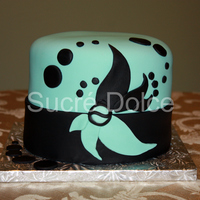 Modern Aqua & Black Chocolate cake with Peanut Butter Truffle filling, iced in whipped Chocolate Ganache, and decorated with aqua and black fondant.