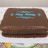Chocolate Ganache Rectangular Birthday Cake Rectangular Tier, Chocolate Ganache-covered cake with blue piping.