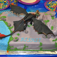How Train Your Dragon Cake Dragon and Hiccup are store bought toys. Big rock is fondant covered rice krispie treat. Small rocks are made from candy melts.