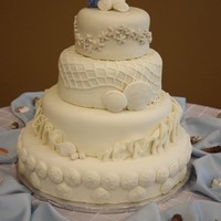 Seashell Wedding Cake Our first wedding cake! The couple asked that it be covered in white fondant and include sand dollars in the design. We came up with the...