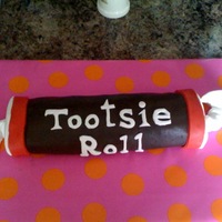 Moms Tootsie Roll Birthday Cake Tootsie roll cake is made with yellow cake and chocolate butter cream. The outside of cake is made with MMF. My first time making fondant!...