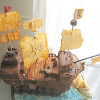 Pirate Ship Cake base w/ MMF and pastillage for sails,posts& plank. RKT for raised decks. Gumpaste pirate & canons. Roughly 8"w x 13"...