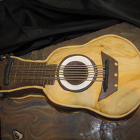 Guitar Cake This is a guitar cake I made. I used spaghetti noodles painted with silver luster dust for the strings. This is 100% edible and is covered...