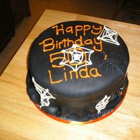 50Th Birthday On Halloween 10 inch round white cake with vanilla buttercream covered in black fondant. Webs are white chocolate and spiders are fondant. Made this...