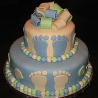Baby Feet & Polka Dots This is a 10 in yellow butter cake and a 6 in yellow chocolate chip cake with butter cream icing and covered in fondant. Fondant feet,...