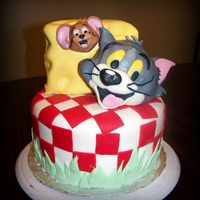 Tom And Jery Birthday Cake... Bottom tier is Chocolate with strawberry buttercream filling. Top "cheese" tier is chocolate with chocolate buttercream filling....