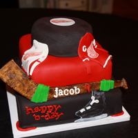 Red Wings Birthday Cake Chocolate fudge cake with layers and layers of buttercream. This cake was for a Red Wings fan who loves to play hockey. Hockey puck on top...
