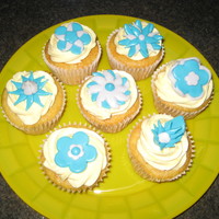 First Time Cupcakes W/ Fondant Flowers:) Banana flavored yellow cake with peanut butter moose filling and buttercream icing with fondant flowers!
